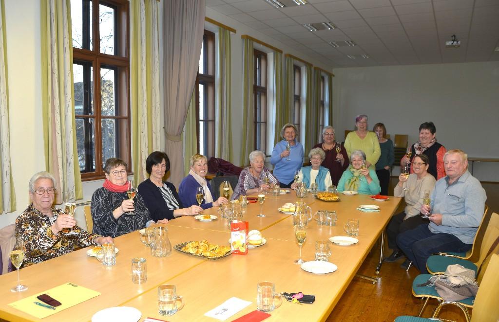Ältere Menschen um eine lange Tafel sitzend