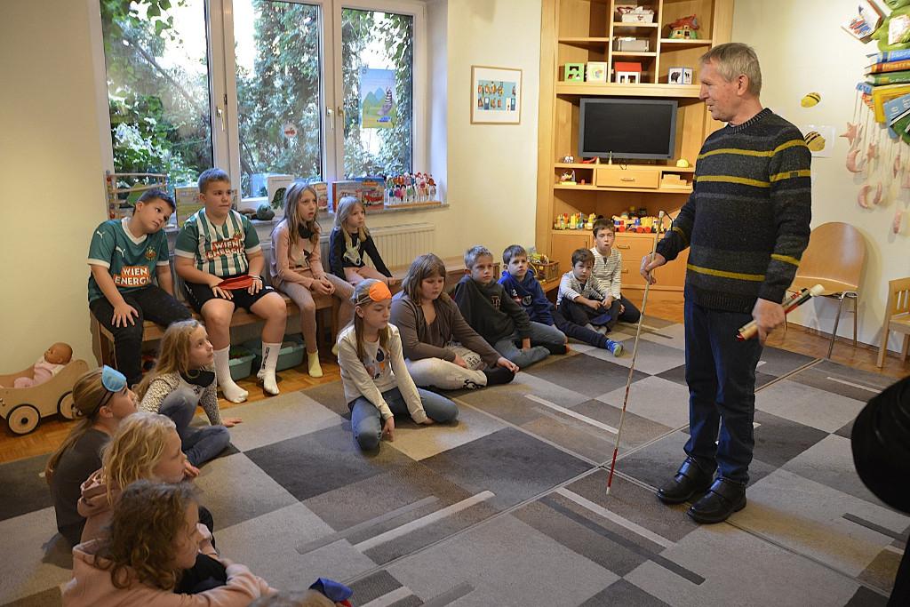 Kinder und Mann mit Blindenstock